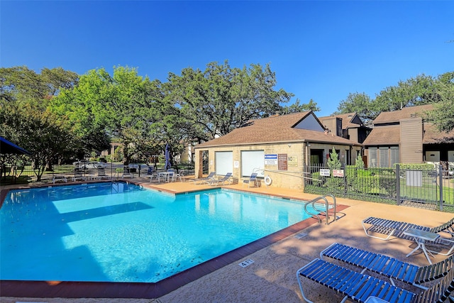 pool with a patio area and fence