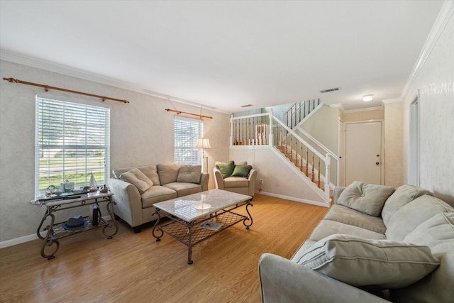 living room with visible vents, baseboards, stairway, light wood finished floors, and crown molding