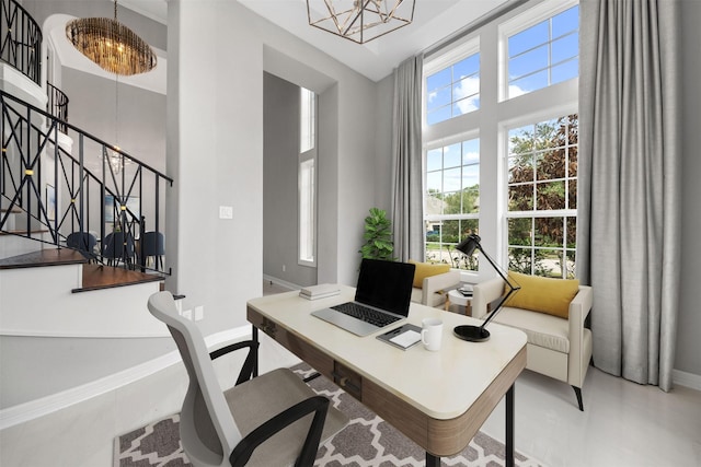 office with a chandelier, a towering ceiling, and baseboards