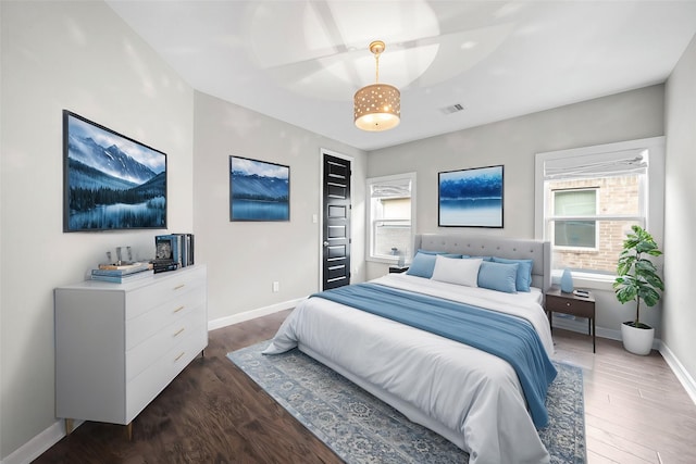 bedroom with dark wood-style floors, baseboards, and visible vents