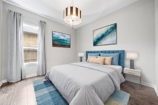 bedroom with wood finished floors and baseboards