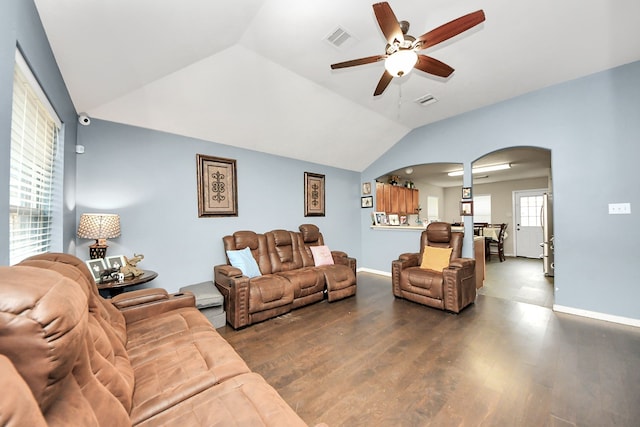 living room featuring arched walkways, lofted ceiling, visible vents, dark wood-type flooring, and ceiling fan