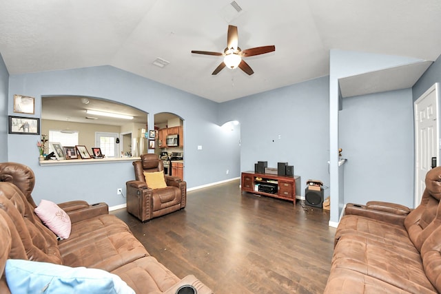 living area featuring arched walkways, dark wood finished floors, lofted ceiling, ceiling fan, and baseboards