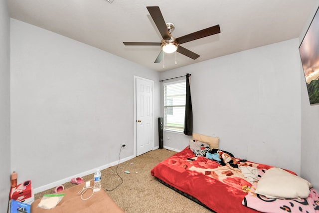 carpeted bedroom with ceiling fan and baseboards