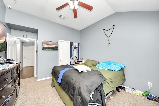 bedroom featuring light carpet, visible vents, baseboards, vaulted ceiling, and a ceiling fan