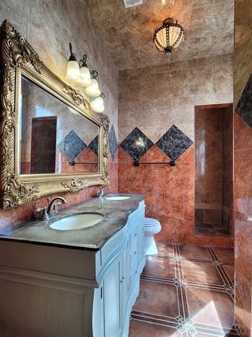 bathroom with tile patterned flooring, a sink, toilet, and double vanity