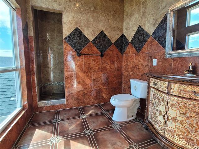 bathroom featuring toilet, tile patterned flooring, tile walls, and vanity