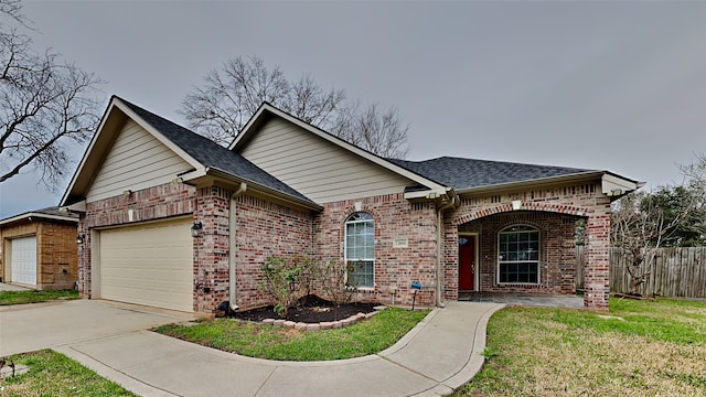 single story home with a front yard, brick siding, driveway, and an attached garage