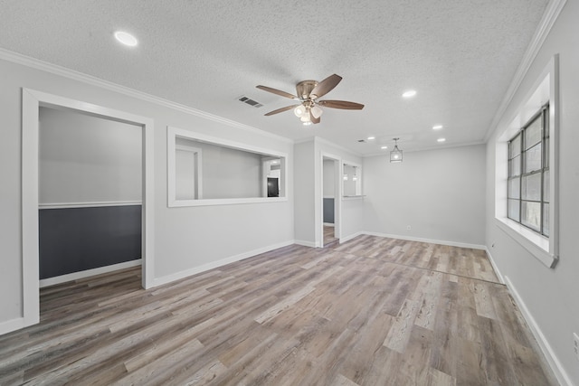 unfurnished living room with a textured ceiling, ornamental molding, baseboards, and light wood-style floors