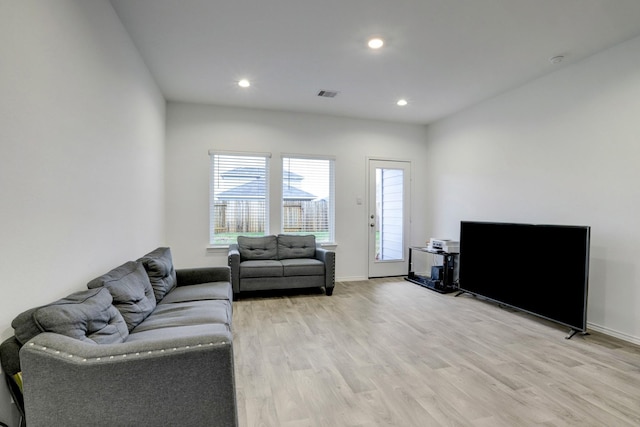 living room with light wood-style flooring, visible vents, and recessed lighting