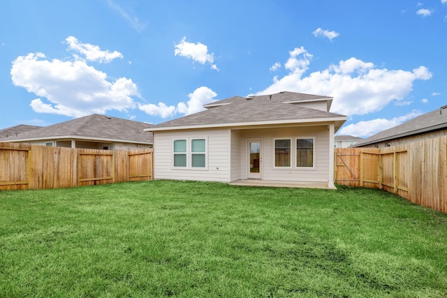 back of house with a lawn and a fenced backyard