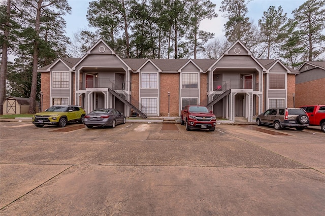 view of front of property with uncovered parking and brick siding