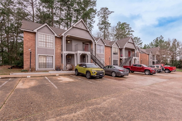 view of property featuring stairs, a residential view, and uncovered parking