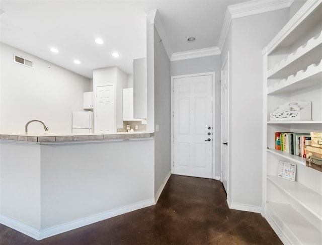 kitchen with light countertops, visible vents, freestanding refrigerator, white cabinetry, and baseboards