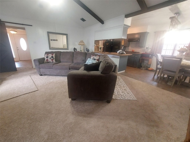 living room featuring visible vents, light carpet, high vaulted ceiling, beam ceiling, and a barn door