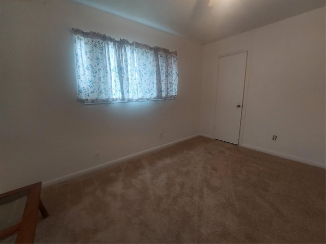 carpeted spare room featuring baseboards