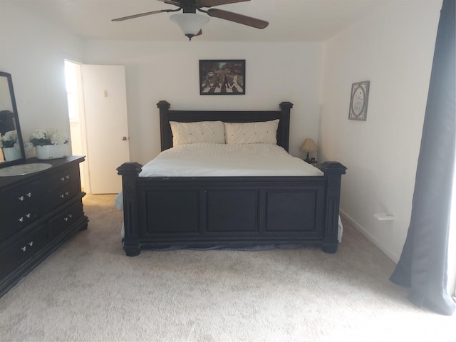 bedroom with light colored carpet and a ceiling fan