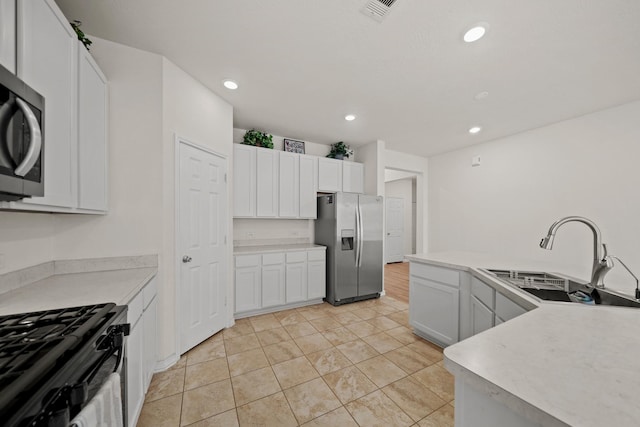 kitchen featuring stainless steel appliances, a sink, light countertops, and white cabinets