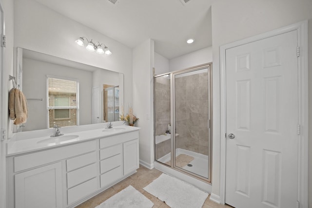 full bath with double vanity, a stall shower, and a sink