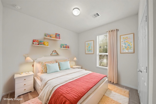 bedroom with baseboards, visible vents, a closet, and light colored carpet