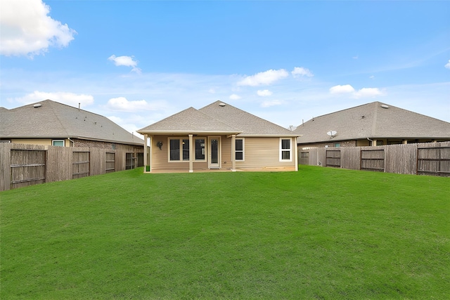 back of house featuring a fenced backyard, a shingled roof, and a yard