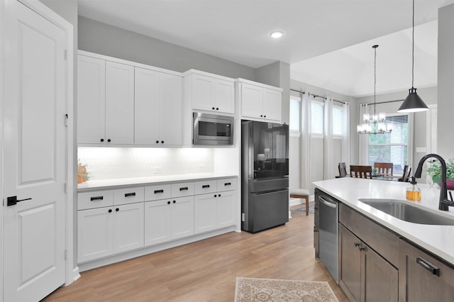 kitchen with appliances with stainless steel finishes, light countertops, and white cabinetry