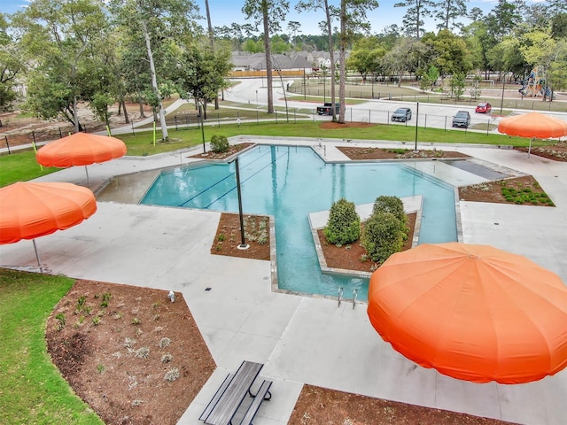 community pool featuring a lawn and fence