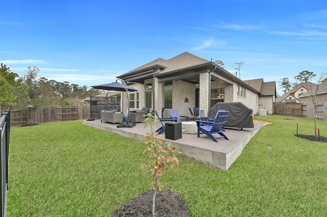 back of property featuring a fenced backyard, an outdoor hangout area, a lawn, and a patio