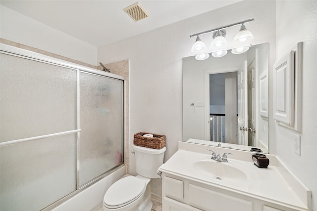 bathroom featuring visible vents, enclosed tub / shower combo, toilet, and vanity