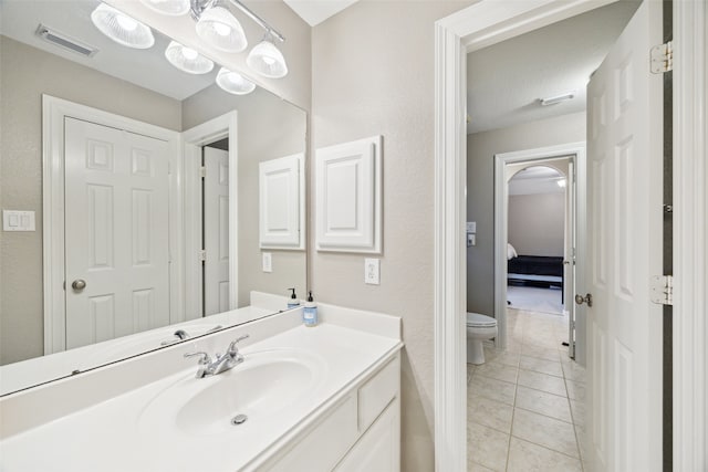 bathroom featuring visible vents, toilet, vanity, and tile patterned flooring