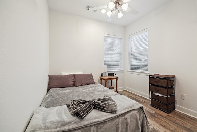 bedroom featuring baseboards, wood finished floors, and a ceiling fan