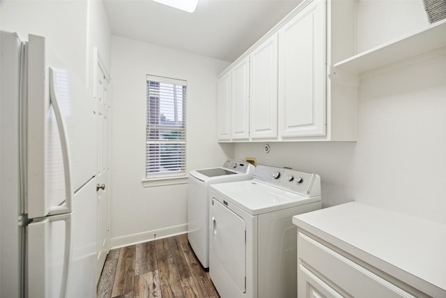 washroom with dark wood finished floors, cabinet space, independent washer and dryer, and baseboards