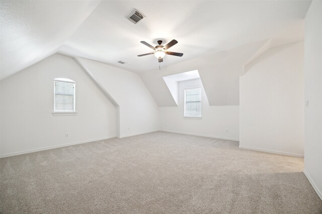 bonus room featuring visible vents, light carpet, lofted ceiling, and ceiling fan