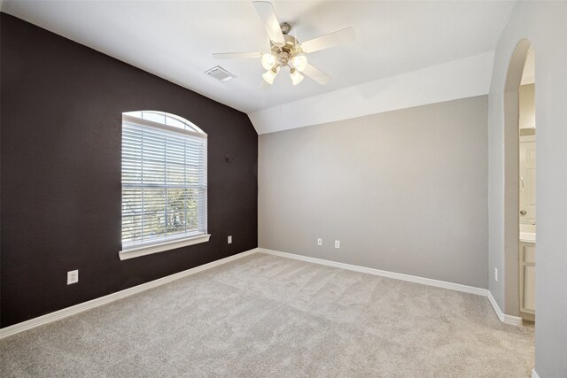 unfurnished room with visible vents, baseboards, ceiling fan, lofted ceiling, and carpet flooring