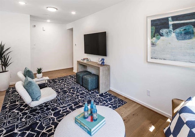 living room with recessed lighting, baseboards, and wood finished floors