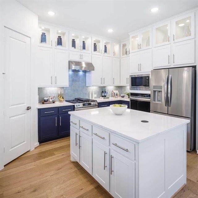 kitchen featuring stainless steel appliances, light countertops, white cabinetry, and under cabinet range hood