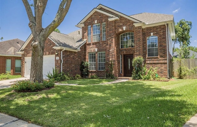 traditional-style home with a garage, brick siding, fence, driveway, and a front lawn