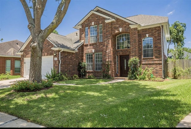 traditional-style home featuring brick siding, a front yard, fence, a garage, and driveway