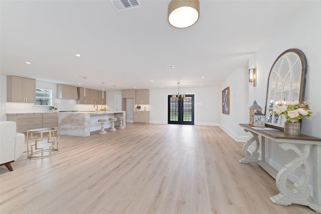 living room with recessed lighting, light wood-type flooring, visible vents, and baseboards