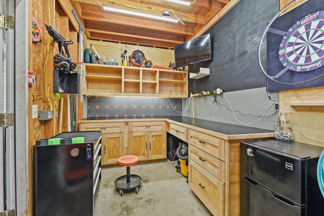 kitchen with dark countertops, light brown cabinets, and concrete floors