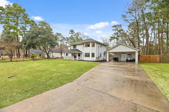 view of front of property with a carport, concrete driveway, a front lawn, and fence