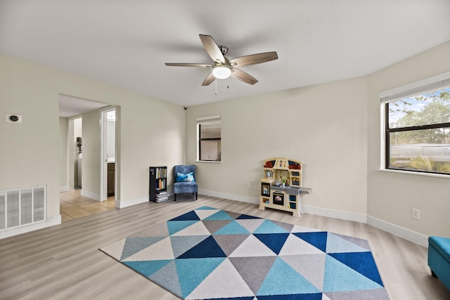 sitting room featuring light wood finished floors, baseboards, and visible vents