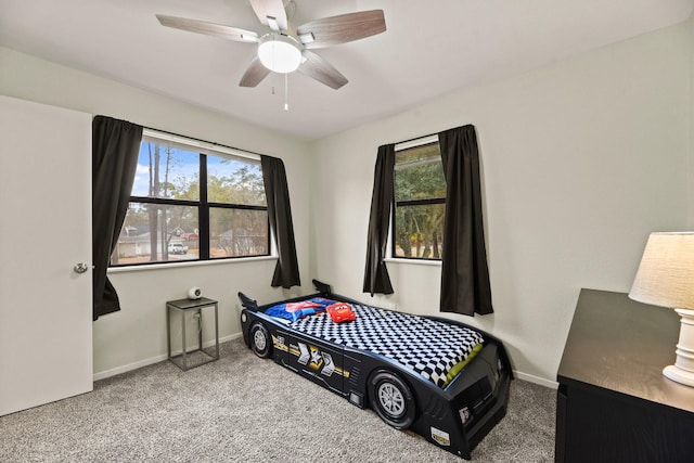 carpeted bedroom with a ceiling fan and baseboards