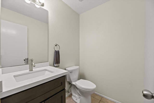 bathroom featuring tile patterned flooring, baseboards, vanity, and toilet