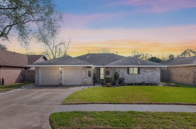 ranch-style house with a garage, a shingled roof, concrete driveway, fence, and a yard