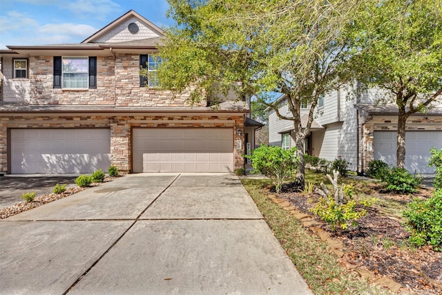 view of front of home featuring an attached garage, stone siding, and concrete driveway