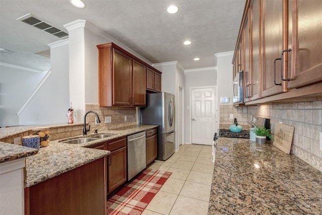 kitchen featuring light tile patterned floors, visible vents, appliances with stainless steel finishes, light stone counters, and a sink