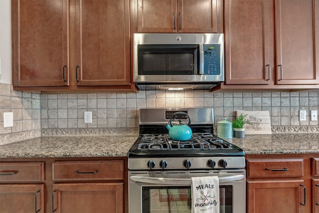 kitchen with appliances with stainless steel finishes, backsplash, and light stone counters