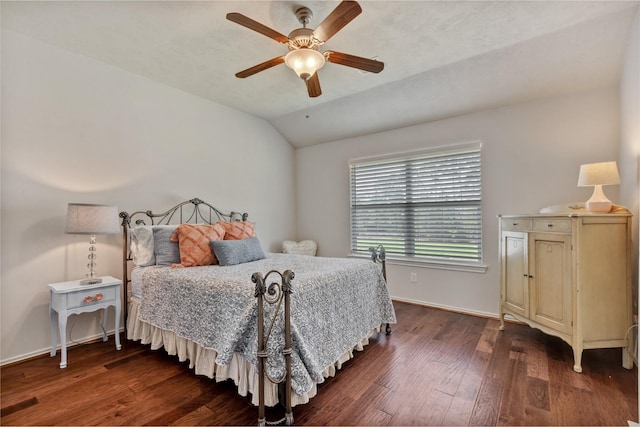 bedroom featuring dark wood-style floors, vaulted ceiling, baseboards, and a ceiling fan