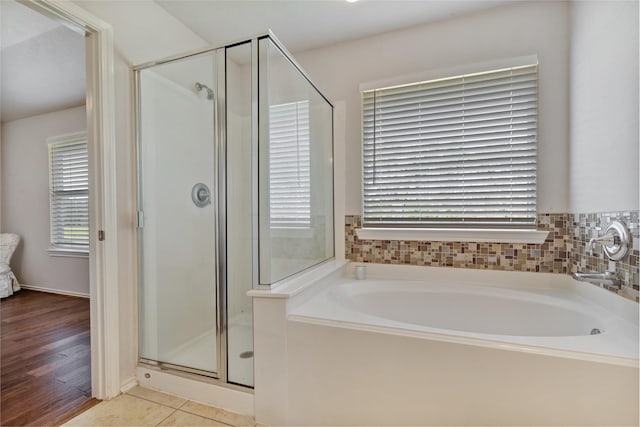 bathroom with a garden tub, plenty of natural light, a shower stall, and tile patterned floors